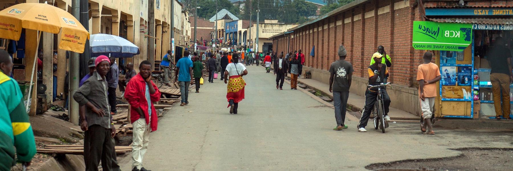 Mahoko, Rubavu, Rwanda: main street on market day with many people entering the town, the cloudy sky indicates that the rainy season has started.
